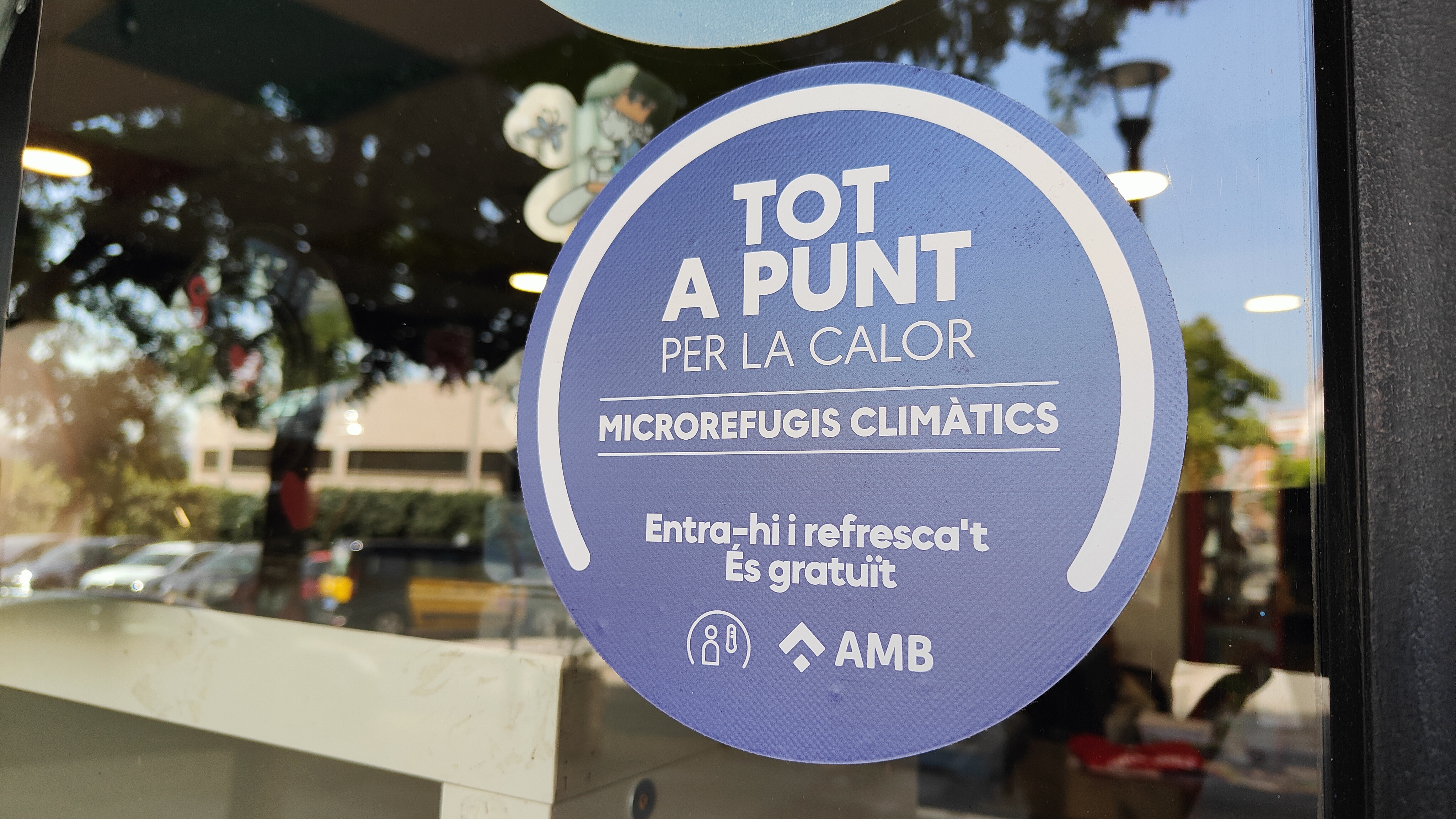Adhesivo de Microrefugio Climático en la puerta de un comercio, Sant Boi de Llobregat